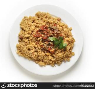 A plate of Lebanese burghul bi banadoura, or cracked wheat with tomatoes. The dish incorporates onion, minced meat and pine nuts, along with the burghul or bulgar wheat from above