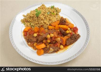 A plate of moroccan style beef tagine served with couscous.