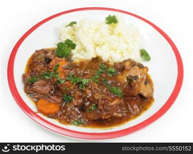 A plate of old-fashioned oxtail stew, served with mashed potato and garnished with Englush parsley