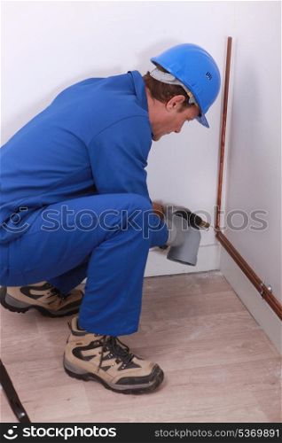A plumber at work with a blowtorch.