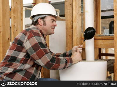 A plumber replacing a bad float in the toilet tank of a newly constructed building. Authentic and accurate content.