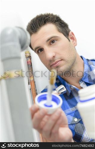 a plumber using some glue