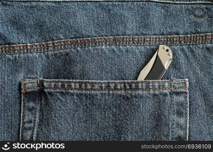 A pocket knife in a back pocket of a denim jean