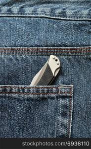 A pocket knife in a back pocket of a denim jean