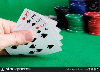 A poker hand with two pair and chips in the background