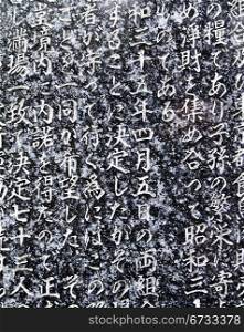 A portion of the writing in Kanji characters on a granite stone tablet in the Benzaiten Temple in Ueno Park in Tokyo.