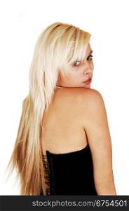 A portrait from the back of a young woman, looking over her shoulder, whit her long blond hair, wearing a black corset for white background.