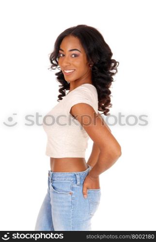 A portrait image of a African American women in a beige blouse andblue jeans with hands in pocket, isolated for white background.