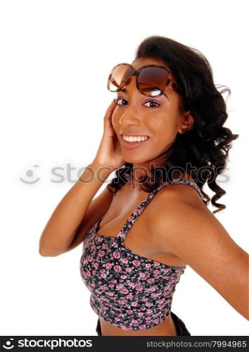 A portrait image of a African American women in a colorful top andsunglasses, with on hands on her head, isolated for white background.