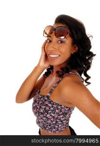 A portrait image of a African American women in a colorful top andsunglasses, with on hands on her head, isolated for white background.