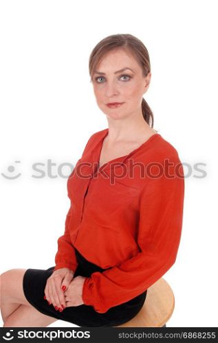 A portrait image of a beautiful young woman sitting in a red blouseand black skirt, with her hair back, isolated for white background