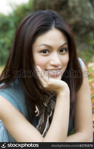 A portrait of a beautiful asian girl at a park