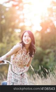 A portrait of a beautiful asian woman with a bicycle outdoor