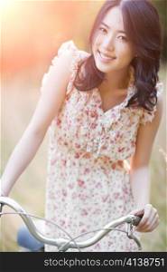 A portrait of a beautiful asian woman with a bicycle outdoor