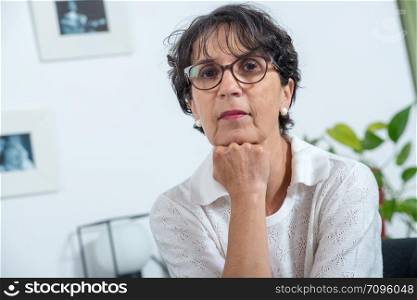 a portrait of a beautiful mature woman with eyeglasses at home
