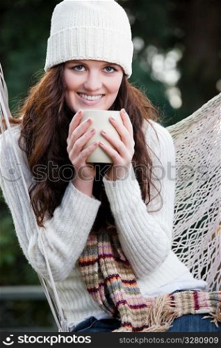A portrait of a beautiful teenager outdoor drinking coffee
