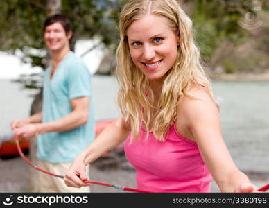 A portrait of a couple setting up a tent