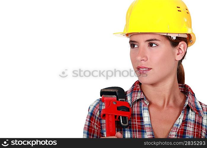 A portrait of a female plumber with a wrench.