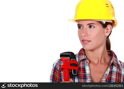 A portrait of a female plumber with a wrench.