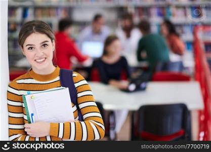 a portrait of a girl holding a notebook in her hand while standing in front of the library