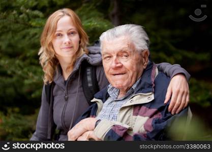A portrait of a granddaughter with her grandfather in the forest