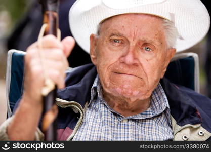 A portrait of a grumpy old man sitting in a chair