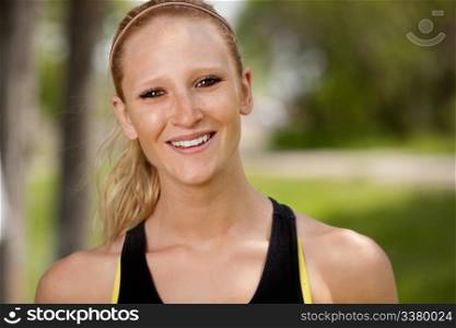 A portrait of a happy female jogger smiling at the camera