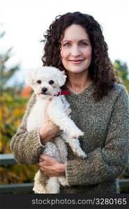 A portrait of a happy mature woman with her dog outdoor