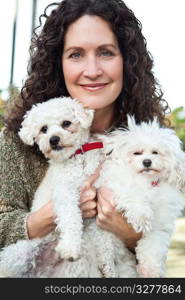 A portrait of a happy mature woman with her dogs outdoor