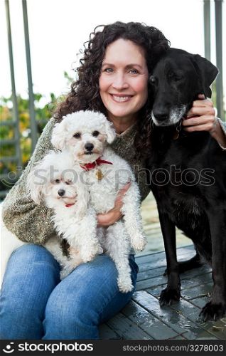 A portrait of a happy mature woman with her dogs outdoor