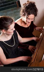 A portrait of a happy mother and daughter playing piano together