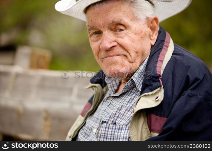 A portrait of a happy senior man on a bench