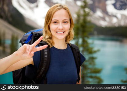 A portrait of a happy smiling girl with a mountain lake in the distant background