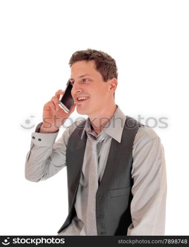 A portrait of a man in a grey shirt and vest talking on his cell phone,isolated for white background.