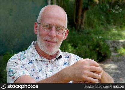 a portrait of a mature man relaxing in the garden