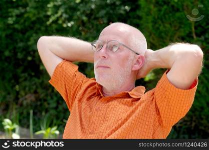 a portrait of a mature man relaxing in the garden