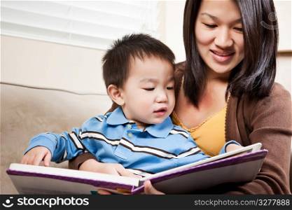 A portrait of a mother and a son reading a book