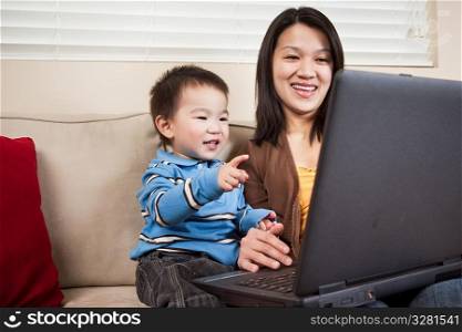 A portrait of a mother and a son using a laptop