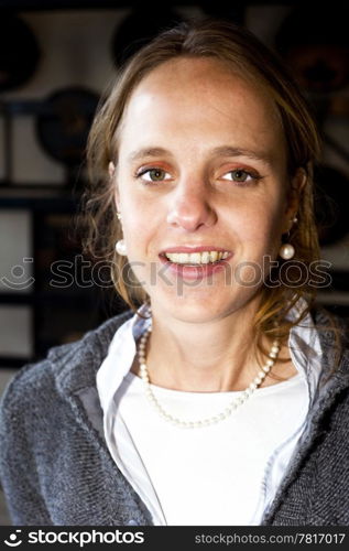 A portrait of a natural looking woman against a dark, grungy, industrial background