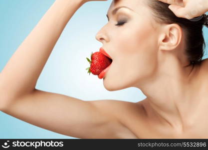 A portrait of a nude sexy woman holding a red-ripe strawberry in her mouth.