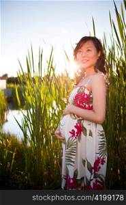 A portrait of a pregnant asian woman outdoor