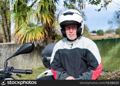 a portrait of a senior biker on his motorcycle