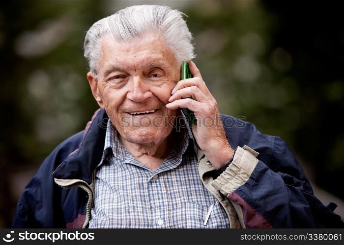 A portrait of a senior using a cell phone outdoors