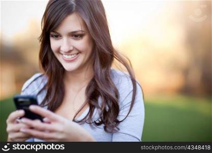 A portrait of a smiling beautiful woman texting with her phone