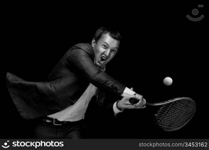 A portrait of a tanned businessman tennis player with a racket against black background.