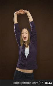A portrait of a teenage girl with her arms in the air