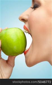 A portrait of a woman biting a green apple with her mouth wide open.