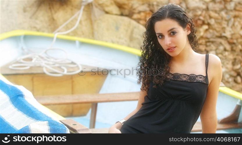 A portrait of a woman with curly hair at the beach.