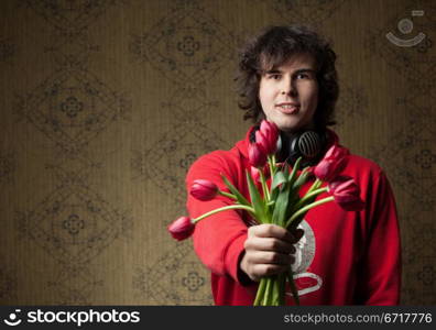 A portrait of a young man with red tulips