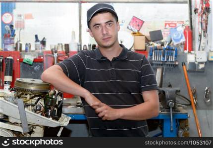 a portrait of a young mechanic in his workshop